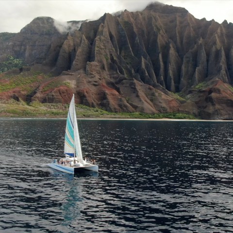a small boat in a body of water with a mountain in the background